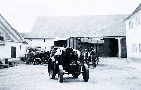 Auf dem Bayertonihof um 1934: Ein Dieselmotor ersetzt den Dampfkesselantrieb der Dreschmaschine. Bei diesem eisenbereiften Lanz handelt es sich um den ersten Traktor des Spar- und Darlehenskassenvereins.